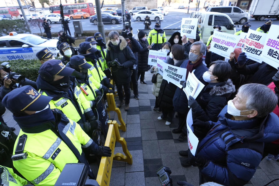 Protesters confront police officers during a rally to oppose Japan's adoption of a new national security strategy near the Japanese Embassy in Seoul, South Korea, Tuesday, Dec. 20, 2022. North Korea threatened Tuesday to take "bold and decisive military steps" against Japan as it slammed Tokyo's adoption of a national security strategy as an attempt to turn the country into an aggressive military power. The banners read "Stop military cooperation between South Korea, the U.S. and Japan military alliance." (AP Photo/Ahn Young-joon)