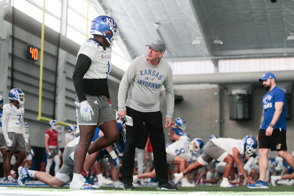 Kansas football coach Lance Leipold talks with senior safety Kenny Logan Jr. (1) during a spring practice earlier this year in Lawrence. The team has posted several episodes of “Wat’s Happenin'? With Kenny Logan Jr” on Twitter.