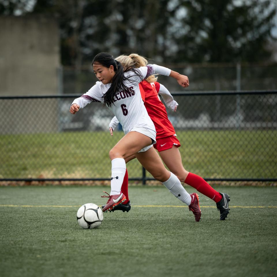 Albertus Magnus' Gabby Chan dribbles the ball under pressure at Tompkins Cortland Community College in Dryden on Sunday, November 13, 2022.