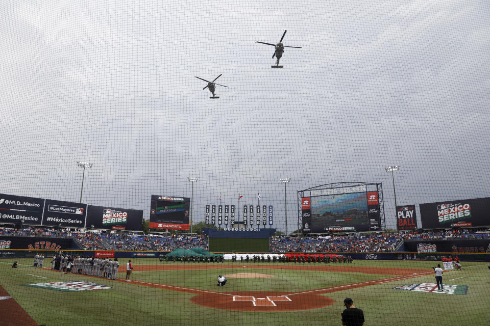 Helicopters fly over the stadium at the start of a baseball game between the Los Angeles Angels and Houston Astros, in Monterrey, Mexico, Sunday, May 5, 2019. (AP Photo/Rebecca Blackwell)wld