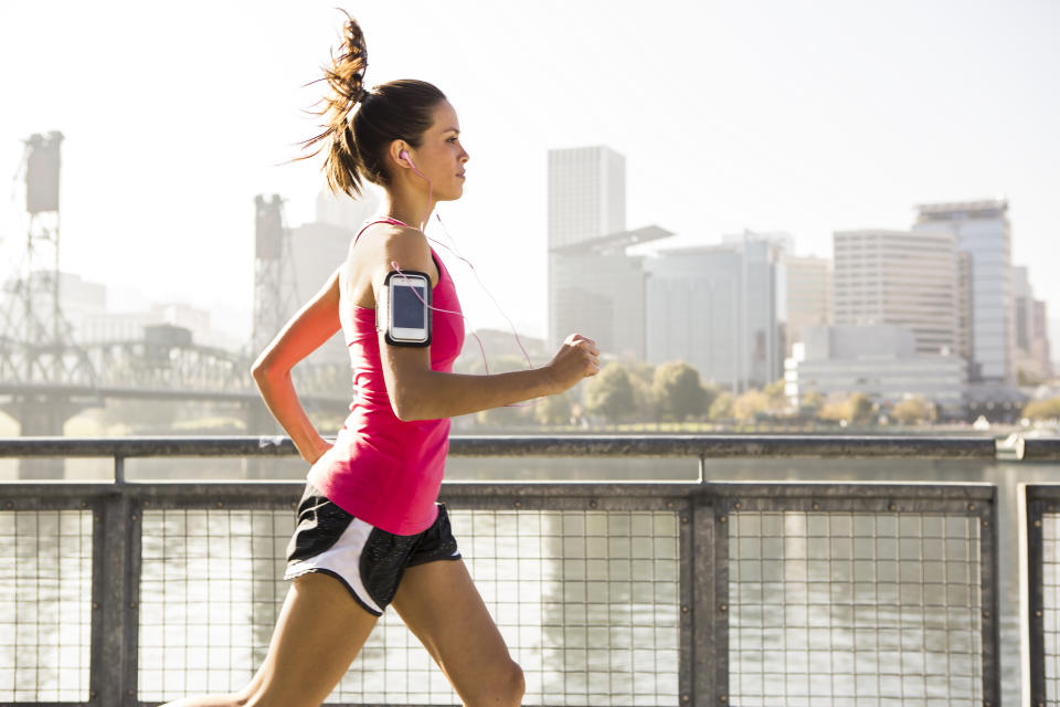 A female listening to music and jogging across a bridge in Portland, Oregon.