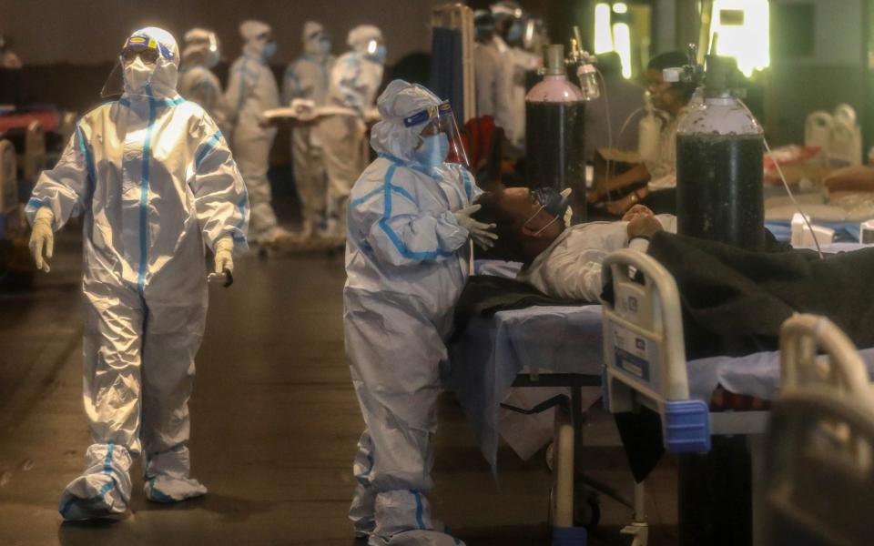 Indian doctors wearing examine patients inside a Covid-19 care centre and isolation ward facility near a hospital in New Delhi - RAJAT GUPTA/EPA-EFE/Shutterstock