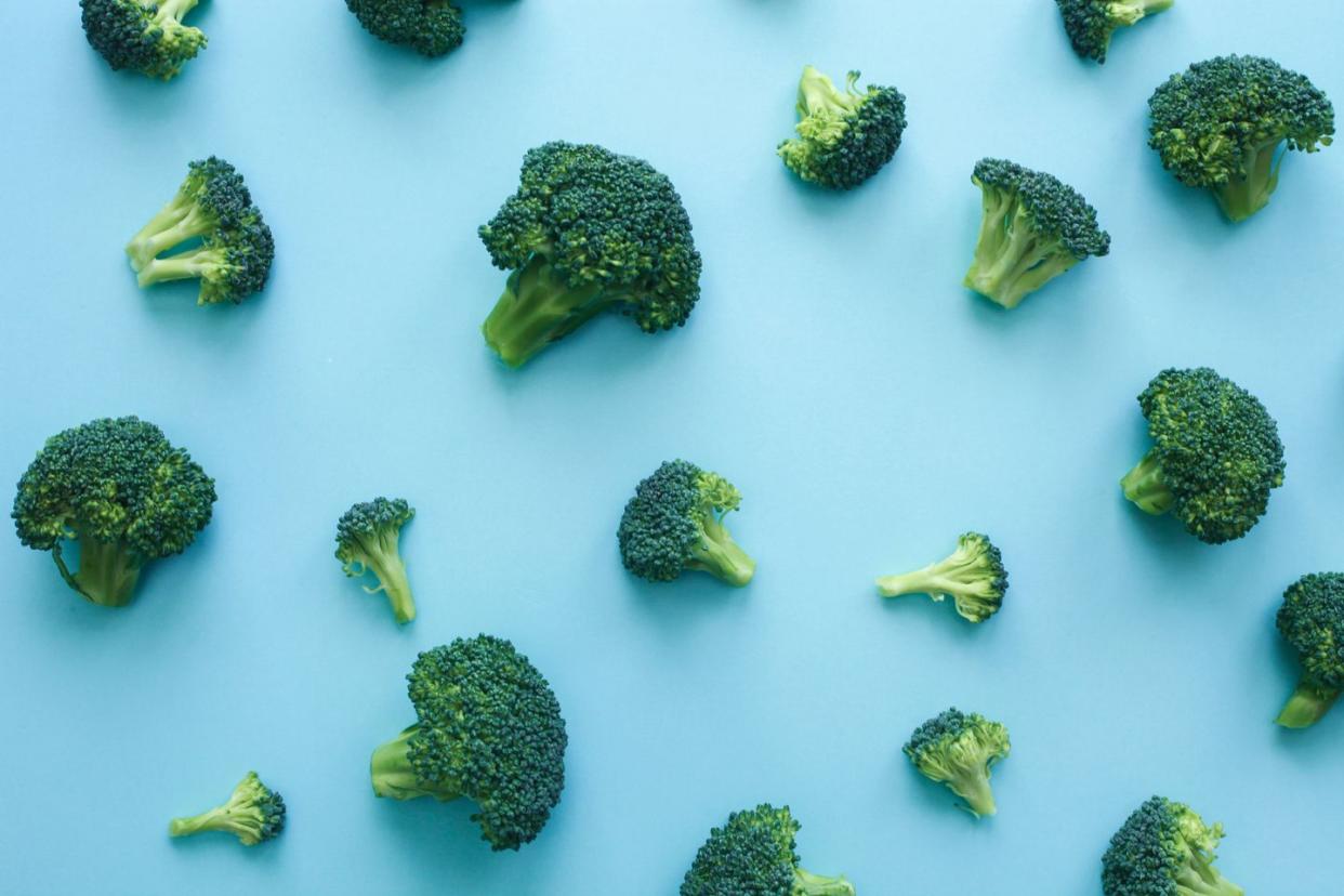 pattern of fresh broccoli over blue background vegan healthy food