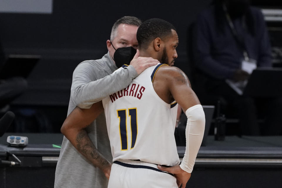 Denver Nuggets coach Michael Malone, left, talks with guard Monte Morris during the first half of an NBA basketball game against the Sacramento Kings in Sacramento, Calif., Saturday, Feb. 6, 2021. (AP Photo/Rich Pedroncelli)