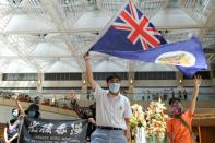 A pro-democracy demonstrator waves the British colonial Hong Kong flag during a protest against new national security legislation in Hong Kong