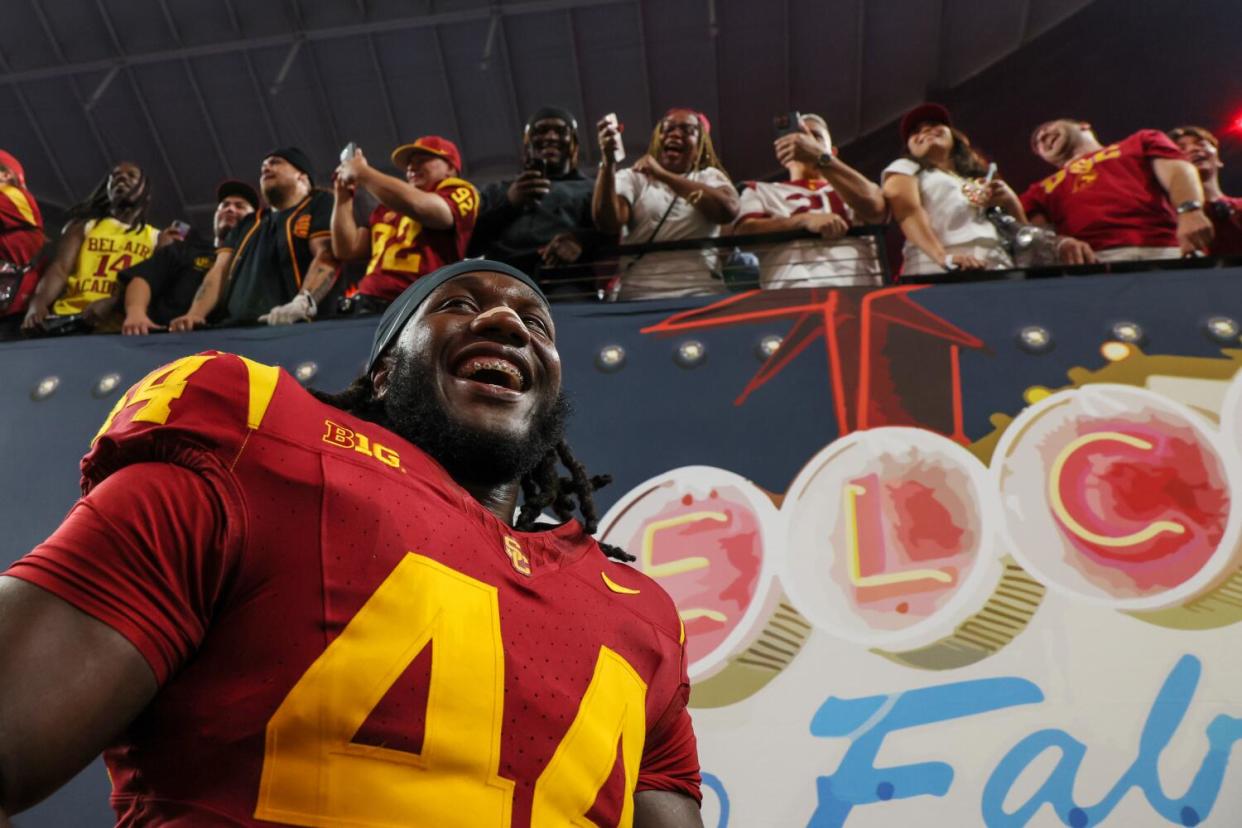 USC Trojans defensive end Sam Greene smiles while family celebrates in the stands above him.