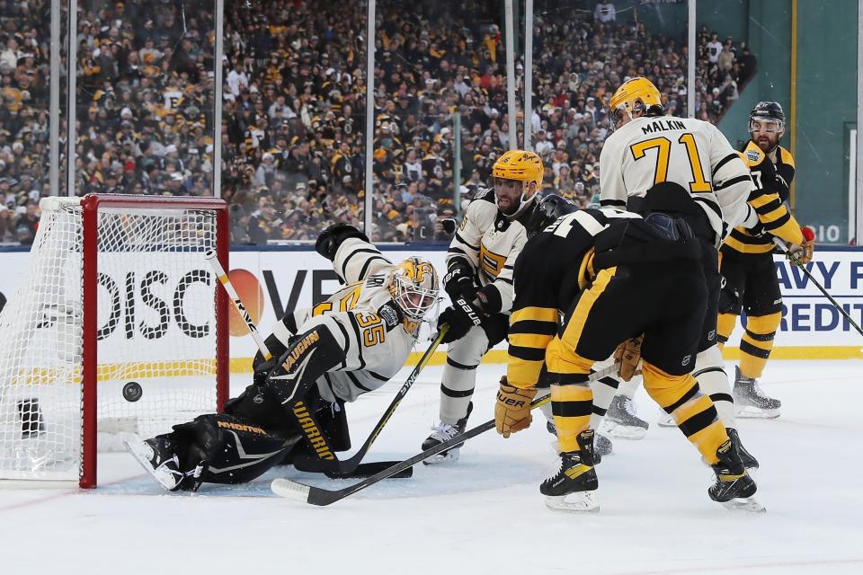 Pittsburgh Penguins goalie Tristan Jarry (35) deflects a shot in front of Boston Bruins' Jake DeBrusk (74) during the first period of the NHL Winter Classic hockey game, Monday, Jan. 2, 2023, at Fenway Park in Boston. (AP Photo/Michael Dwyer)