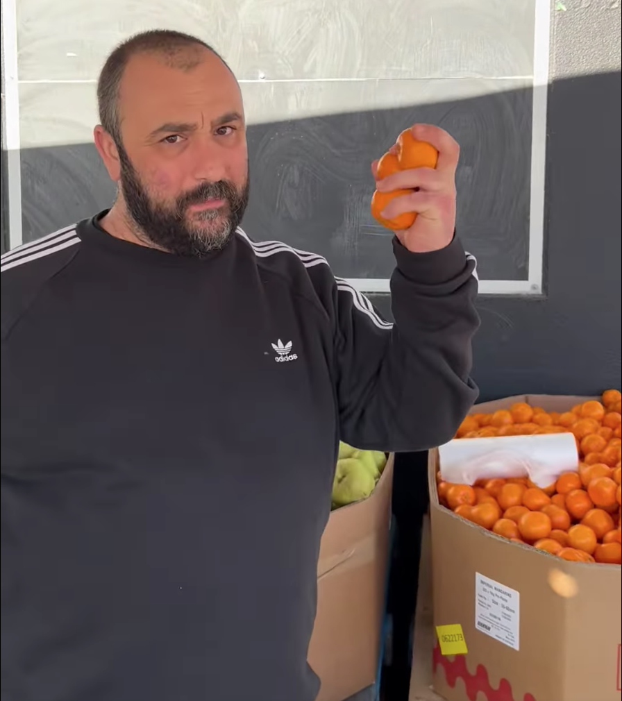 Adelaide grocer Johnny Kapiris holding mandarins