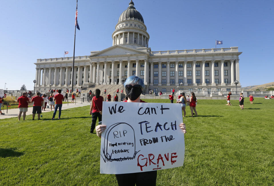 Utah school teacher Brittany Goddard protests at the Utah State Capitol, Friday, Aug. 7, 2020, in Salt Lake City. The Utah Board of Education has rejected multiple proposals requiring stricter precautions against the coronavirus as schools reopen across the state. The board voted 9-5 Thursday against a series of mandates, including one that would limit the number of students in a classroom if community spread spikes above the 5% reopening threshold set by the World Health Organization, the Deseret News reported. (AP Photo/Rick Bowmer)