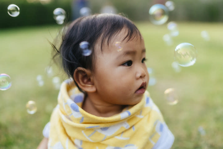 A baby surrounded by bubbles