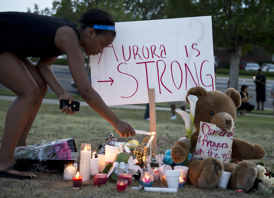 Mourners at a vigil light candles near theater where 12 people were killed July 20, 2012 in Aurora, Colo.