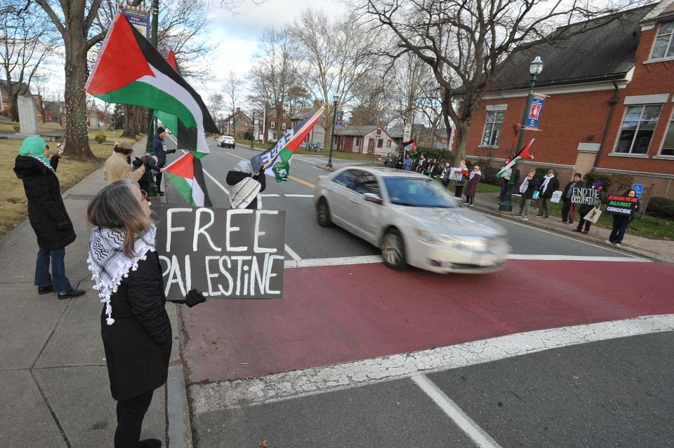 Palestinian supporters get the attention of drivers on Washington Street, near Braintree Town Hall, on Sunday, Dec. 31, 2023. They are calling for an end to Israel's military action in Gaza.