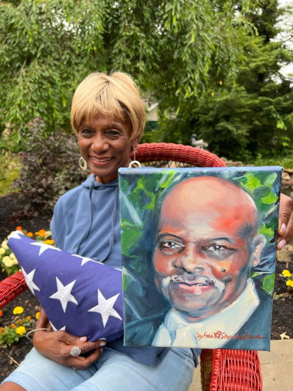 Betty Smith, 82, of Jackson Township holds a portrait of her late husband, Mark M. Smith, who died of COVID last summer. She also holds a flag representing his military service. A one-mile remembrance walk for those lost to COVID is scheduled for Saturday morning as part of the African American Arts Festival in downtown Canton.