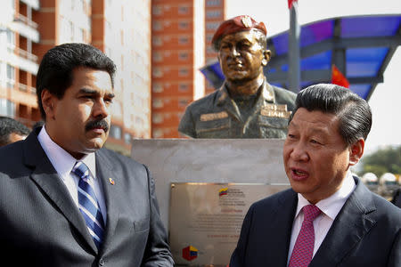 FILE PHOTO: China's President Xi Jinping (R) speaks with Venezuela's President Nicolas Maduro in front of a statue of Venezuela's late president Hugo Chavez during a ceremony in Caracas July 21, 2014. REUTERS/Carlos Garcia Rawlins/File Photo