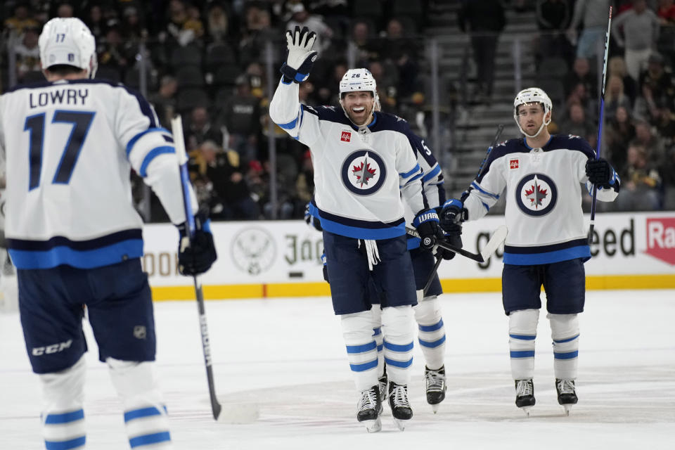 Winnipeg Jets right wing Blake Wheeler, center, celebrates after center Adam Lowry (17) scored against the Vegas Golden Knights during the third period of Game 1 of an NHL hockey Stanley Cup first-round playoff series Tuesday, April 18, 2023, in Las Vegas. (AP Photo/John Locher)