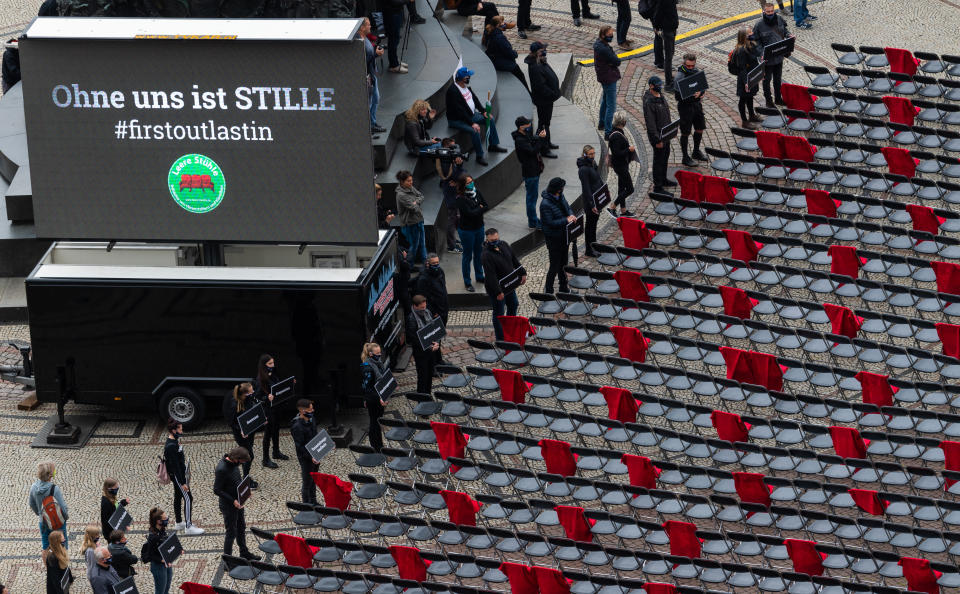 Stühle, von denen einige als Symbol für verkaufbare Sitzplätze bei Veranstaltungen mit roten Decken behängt sind, stehen während der Demonstration vor der Semperoper, (Bild: Robert Michael/dpa)