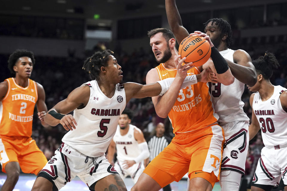 Tennessee forward Uros Plavsic, third from right, is defended by South Carolina guard Meechie Johnson (5) and Josh Gray, second from right, during the first half of an NCAA college basketball game Saturday, Jan. 7, 2023, in Columbia, S.C. (AP Photo/Sean Rayford)