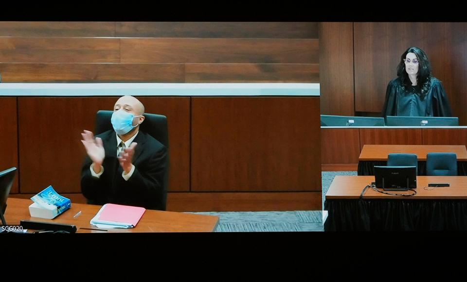 Darrell Brooks claps as he appears via video from an adjacent courtroom after being removed by Waukesha County Circuit Court Judge Jennifer Dorow (on screen to the right) for repeated interruptions in a Waukesha County Circuit Court during the second day of jury selection in Waukesha on Tuesday, Oct. 4, 2022. Brooks, who is representing himself during the trial, is charged with driving into the Waukesha Christmas Parade last year killing six people and injuring dozens more. He faces six counts of first-degree intentional homicide and 71 other counts.