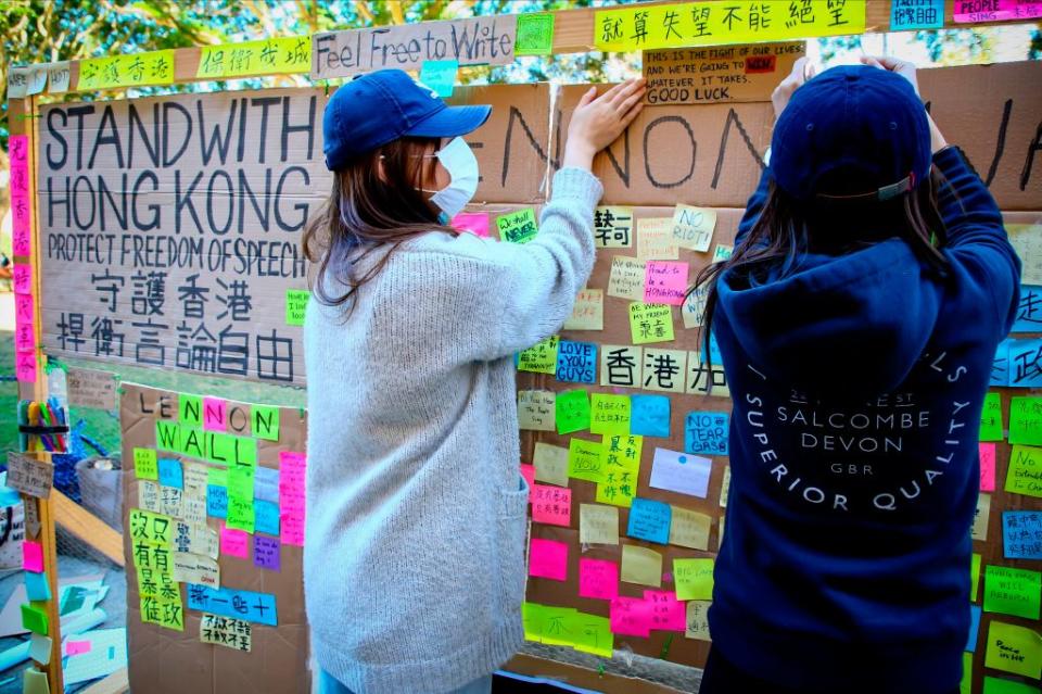 This photo taken on August 9, 2019 shows supporters of the Hong Kong pro-democracy protests posting notes on a makeshift 