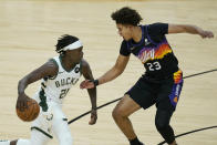 Milwaukee Bucks guard Jrue Holiday (21) drives against Phoenix Suns forward Cameron Johnson (23) during the first half of Game 5 of basketball's NBA Finals, Saturday, July 17, 2021, in Phoenix. (AP Photo/Ross D. Franklin)