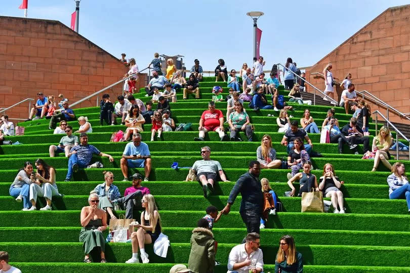 People relaxing in the warm weather in Liverpool One Chavasse Park