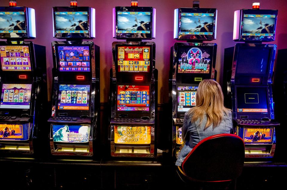 A patron plays a game May 11 at Thunderbird Casino for its soft reopening. The casino in Norman has spaced out machines 6 feet apart while implementing temperature checks at the door and enforcing masks.