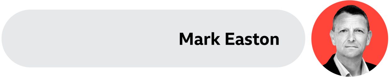 A grey box with Mark Easton's name written on it. His face is on the right side. 