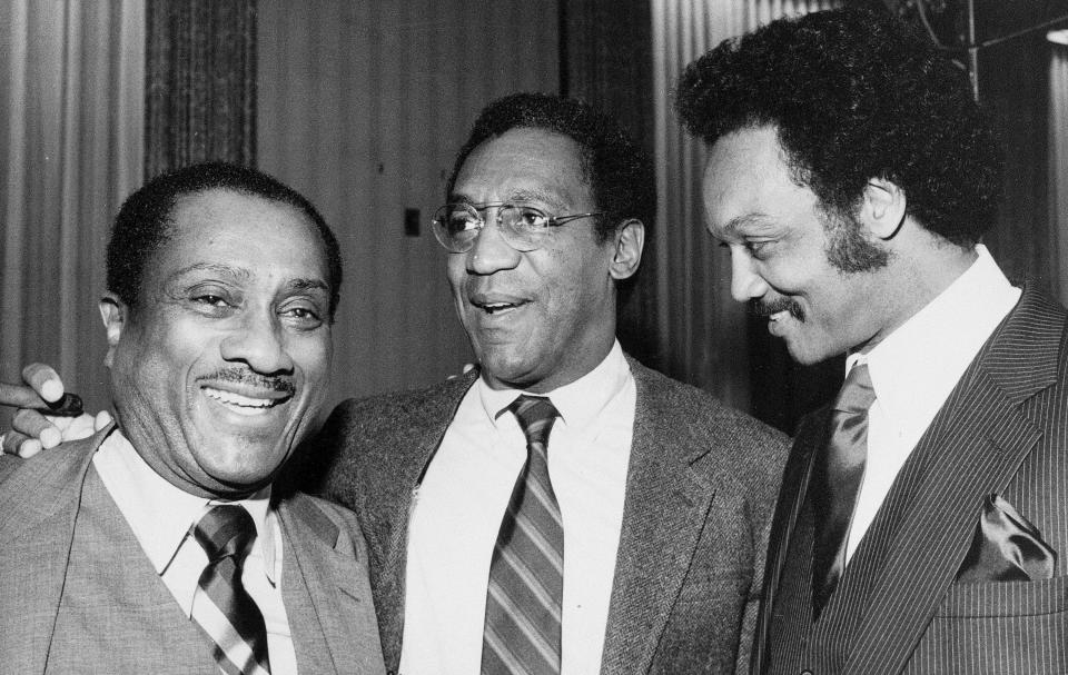 John H. Johnson, publisher of Jet and Ebony magazines, left, and actor Bill Cosby, center, join the Rev. Jesse Jackson at a benefit reception for Operation PUSH, in Chicago, Ill., on April 1, 1982. (AP Photo)