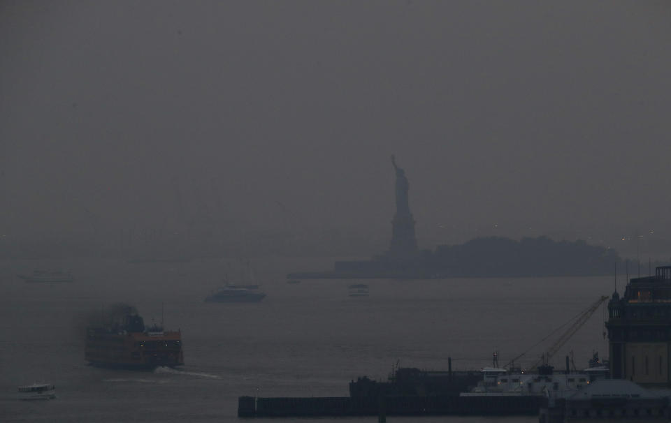 FILE - In this Tuesday, July 20, 2021 file photok the Staten Island Ferry departs from the Manhattan terminal through a haze of smoke with the Statue of Liberty barely visible in New York. Wildfires in the American West, including one burning in Oregon that's currently the largest in the U.S., are creating hazy skies as far away as New York as the massive infernos spew smoke and ash into the air in columns up to six miles high. (AP Photo/Julie Jacobson)