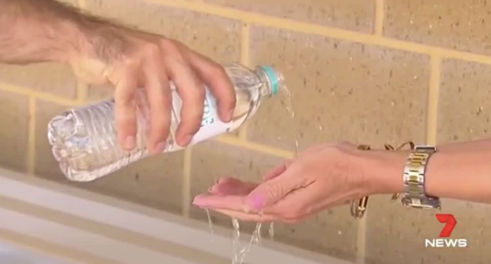 Staff and students washing their hands with bottled water on Wednesday. Source: 7 News