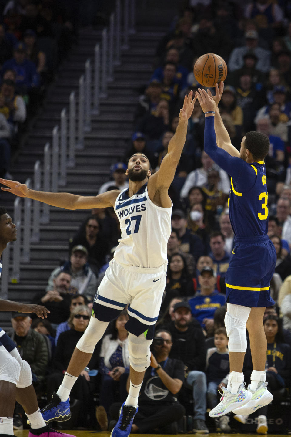 Golden State Warriors guard Stephen Curry, right, attempts a 3-point basket over Minnesota Timberwolves center Rudy Gobert (27) during the second quarter of an NBA basketball game, Sunday, March 26, 2023, in San Francisco. (AP Photo/D. Ross Cameron)