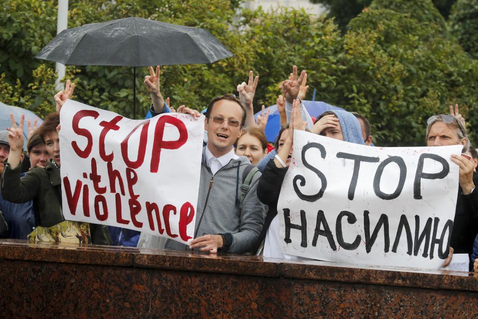 Protesters with posters reading "Stop the violence" gather in front of the Minsk Tractor Works Plant to support workers leaving the plant after their work shift in Minsk, Belarus, Wednesday, Aug. 19, 2020. Belarus President Alexander Lukashenko repeatedly rejected demands to step down and bristled at the idea of talks with the opposition, denouncing the coordination council on Tuesday as a "an attempt to seize power" in the country. Nevertheless, the council is set to convene for the first time Wednesday. (AP Photo/Dmitri Lovetsky)