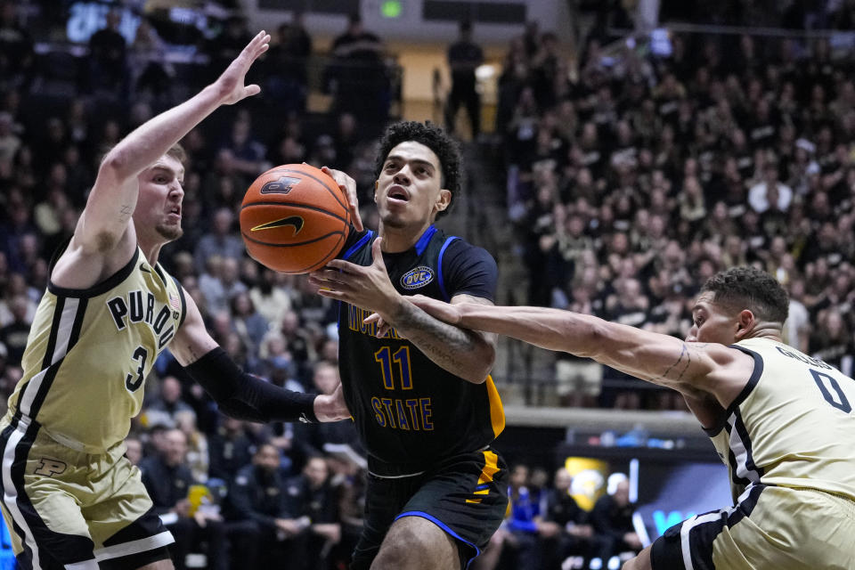 Morehead State guard Trent Scott (11) is fouled by Purdue forward Mason Gillis (0) as he's defended by Purdue guard Braden Smith (3) during the first half of an NCAA college basketball game in West Lafayette, Ind., Friday, Nov. 10, 2023. (AP Photo/Michael Conroy)