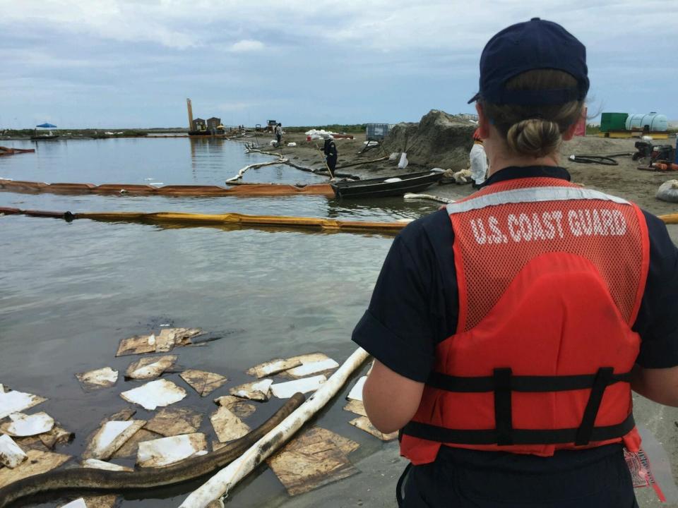 Coast Guard Petty Officer 3rd Class Lyndsey Slabe surveys the cleanup efforts in Bay Long, La., Sept. 10, 2016. A Houston dredging company has been ordered Thursday, June 16, 2022, to pay a $1 million fine for an oil spill that occurred when a subcontractor cut through a pipeline during Louisiana barrier island restoration work in 2016. (Petty Officer 3rd Class Brandon Giles/U.S. Coast Guard via AP)