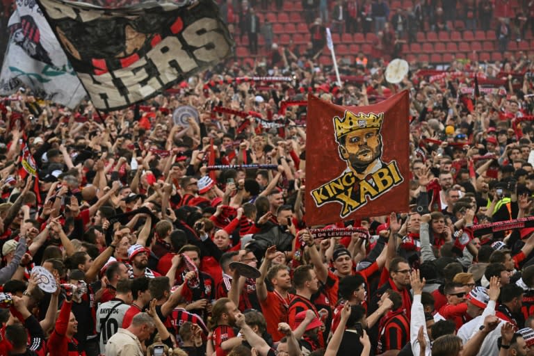 Les supporters du club de football du Bayer Leverkusen célèbrent la victoire de leur club en championnat d'Allemagne après sa victoire 5-0 contre le Werder Brême au stade de Leverkusen le 14 avril 2024. (INA FASSBENDER)