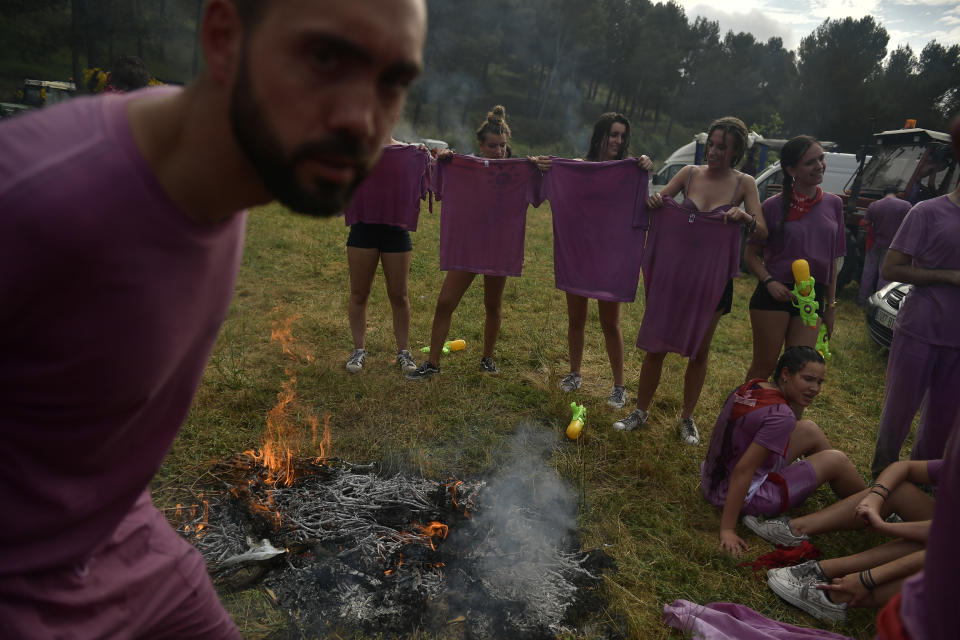 <p>Reveler warm up close to a fire after a wine battle, in the small village of Haro, northern Spain, Friday, June 29, 2018. (Photo: Alvaro Barrientos/AP) </p>