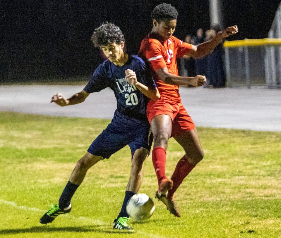 All Saints' Ethan Cajuste battles for the ball against Tampa Univeral on Thursday night in the championship match of the Class 2A, District 7 boys soccer tournament at Sants Fe Catholic.