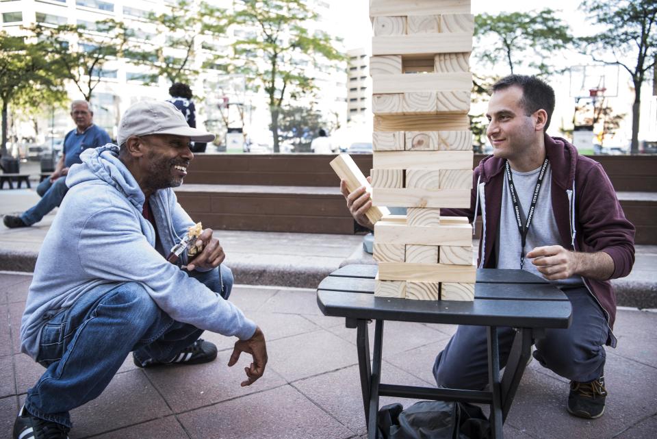 Elynn Royster and Adam Goldberg compete in jumbo Jenga.