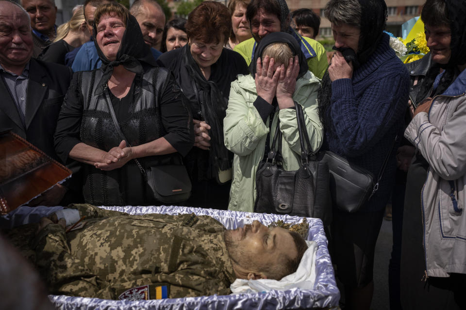 Familiares lloran junto al cuerpo de Pankratov Oleksandr, de 49 años, un militar ucraniano muerto en la provincia de Donetsk, durante su funeral el sábado 14 de mayo de 2022, en Leópolis, Ucrania. (AP Foto/Emilio Morenatti)