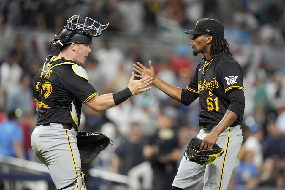 Pittsburgh Pirates catcher Henry Davis (32) and relief pitcher Jose Hernandez (61) congratulate each other after the Pirates beat the Miami Marlins 6-5 in 12 innings of a baseball game, Thursday, March 28, 2024, in Miami. (AP Photo/Wilfredo Lee)