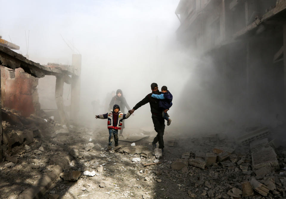 <p>Syrian civlians flee from reported regime air strikes in the rebel-held town of Jisreen, in the besieged Eastern Ghouta region on the outskirts of the capital Damascus, on Feb. 8, 2018. (Photo: Abdulmonan Eassa/AFP/Getty Images) </p>