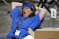 A contractors working for Florida-based company, Cyber Ninjas, yawns as Maricopa County ballots cast in the 2020 general election are examined and recounted, Thursday, May 6, 2021 at Veterans Memorial Coliseum in Phoenix. The audit, ordered by the Arizona Senate, has the U.S. Department of Justice saying it is concerned about ballot security and potential voter intimidation arising from the unprecedented private recount of the 2020 presidential election results. (AP Photo/Matt York, Pool)