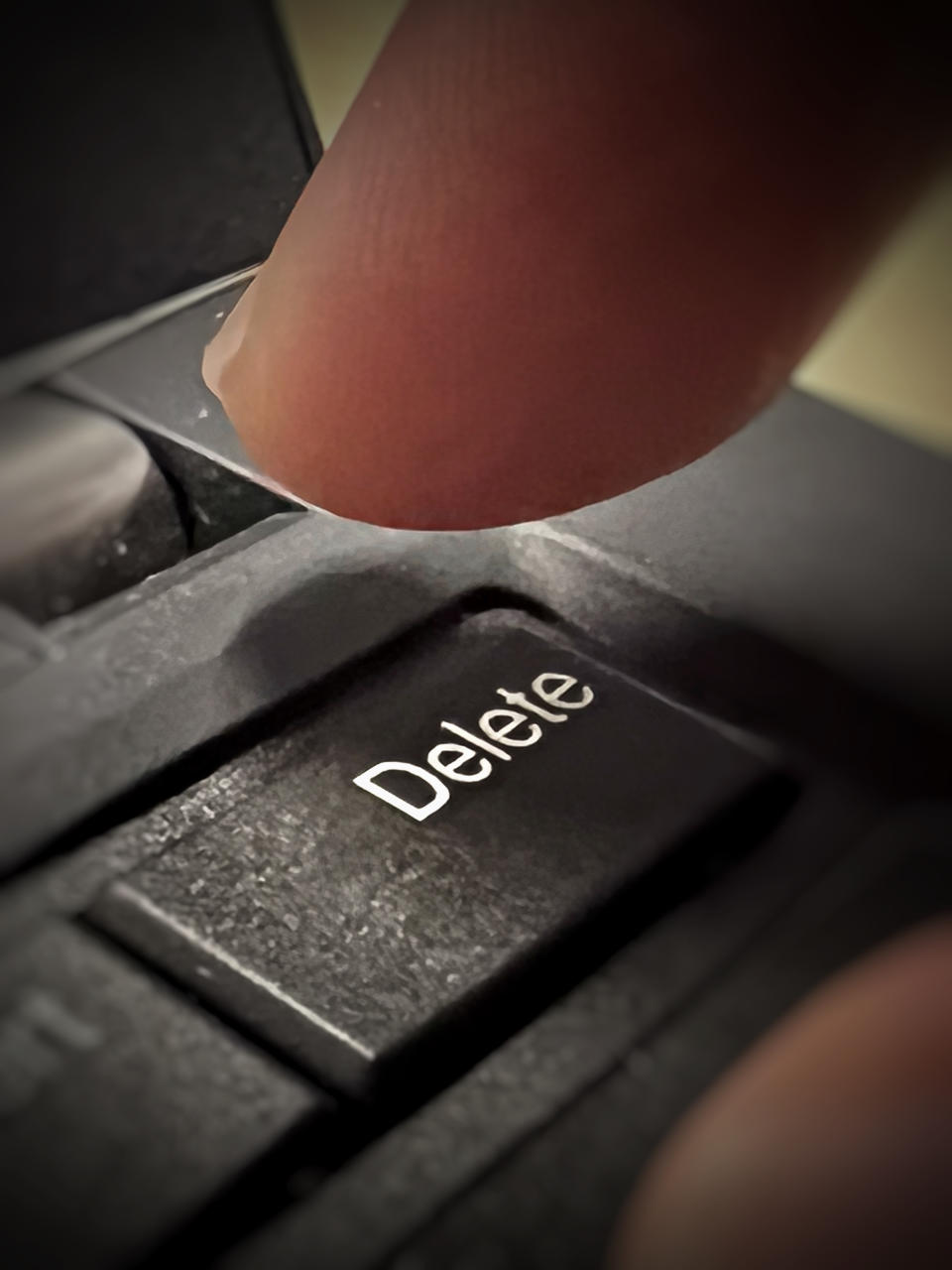 Close-up of a finger above a keyboard's delete key