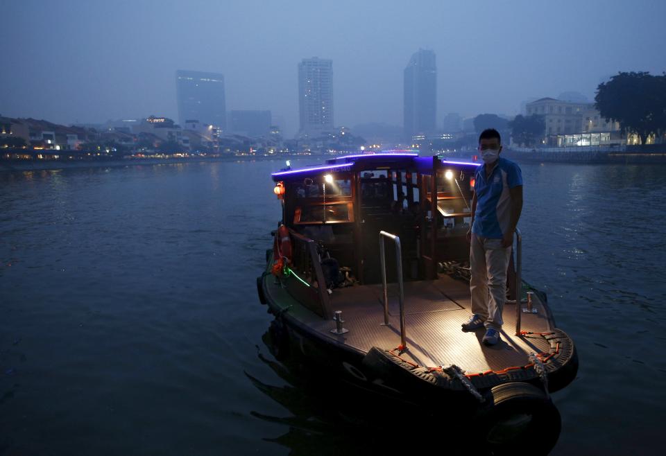 A bumboat approaches to dock near the haze-shrouded central business district in Singapore