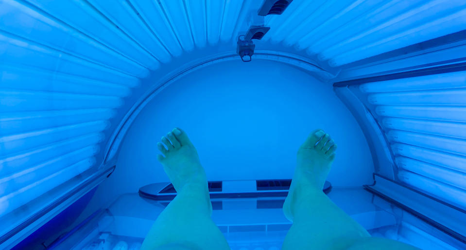 A woman pictured in a tanning bed.