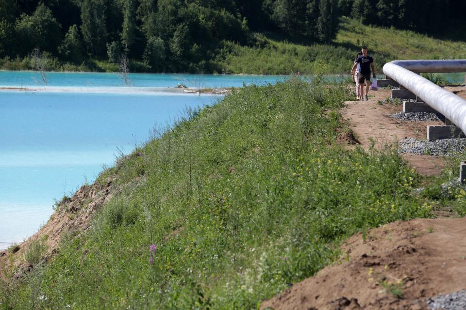 Young people walk by a Novosibirsk energy plant's ash dump site - nicknamed the local "Maldives" - on July 11, 2019. (Photo: Rostislav Netisov/AFP/Getty Images)