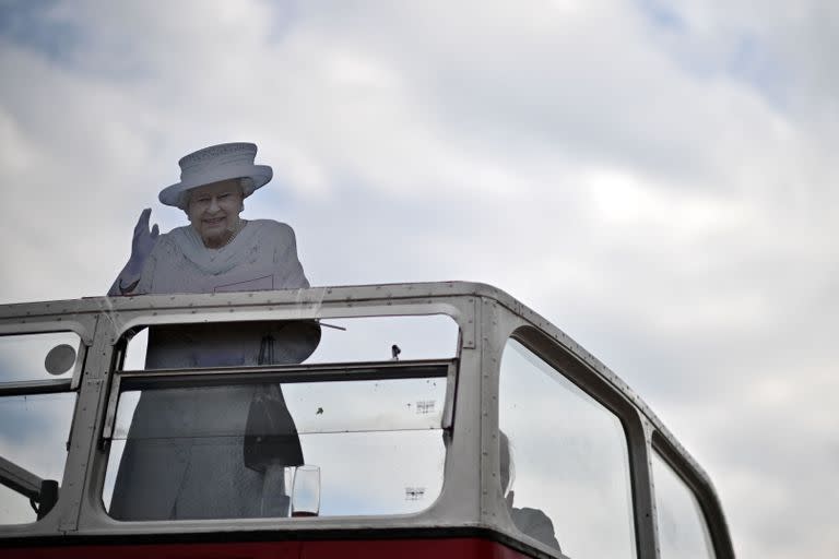 Una gigantografía de la reina Isabel II de Gran Bretaña aparece en el piso superior de un autobús en el segundo día de la reunión de carreras de caballos del Festival Epsom Derby