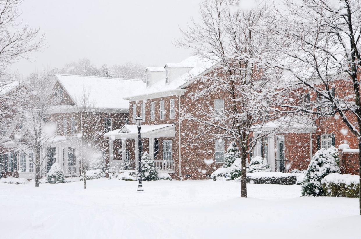 Row of brick houses in snowstorm.