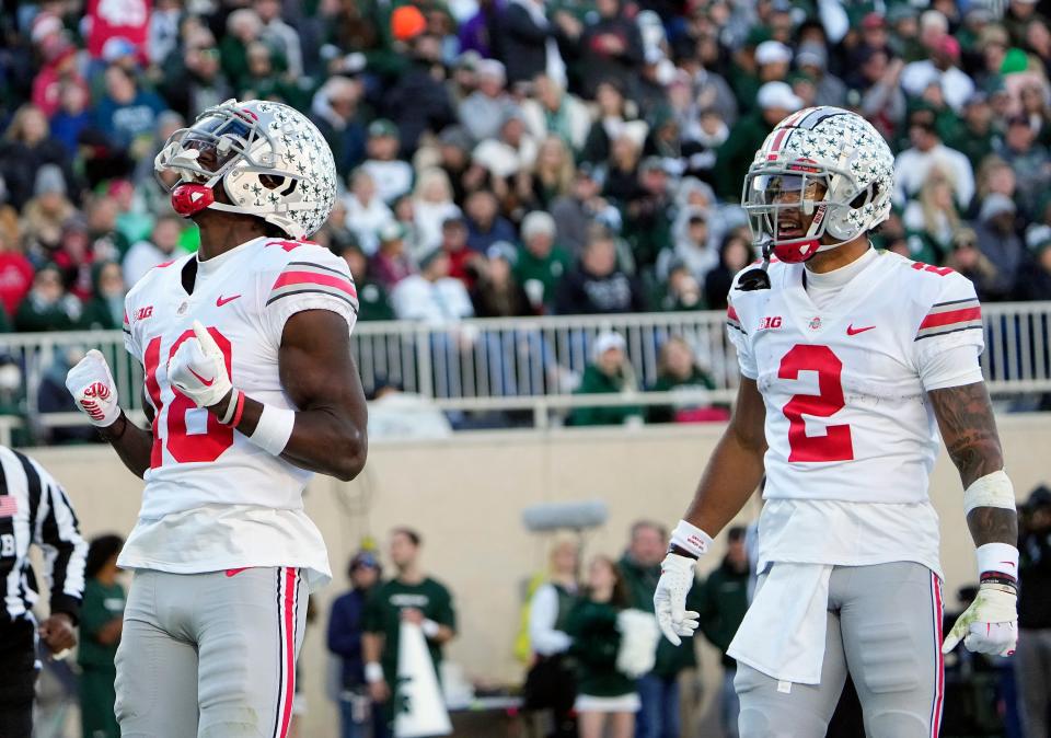 Oct 8, 2022; East Lansing, Michigan, USA; Ohio State Buckeyes wide receiver Marvin Harrison Jr. (18) celebrates his touchdown catch with wide receiver Emeka Egbuka (2) in the second quarter of the NCAA Division I football game between the Ohio State Buckeyes and Michigan State Spartans at Spartan Stadium. 