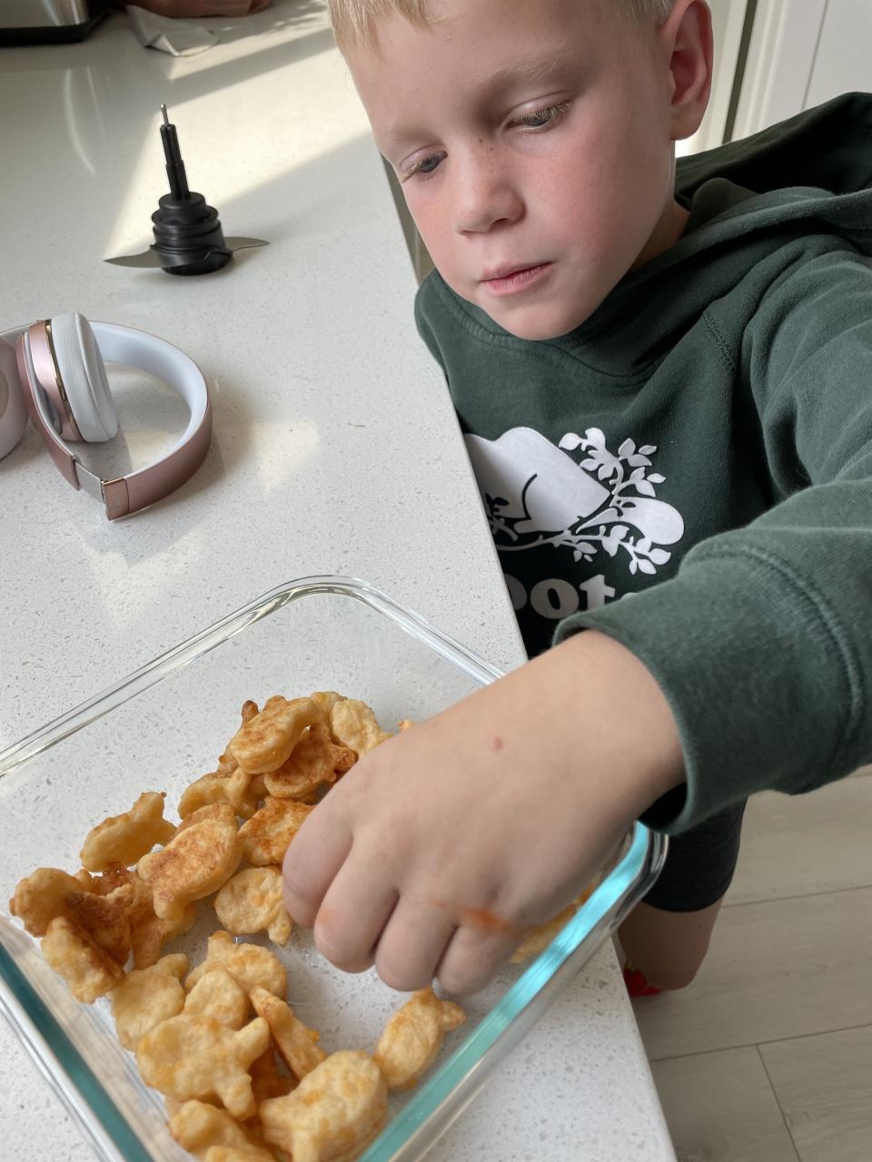 The author's son eating cheese crackers